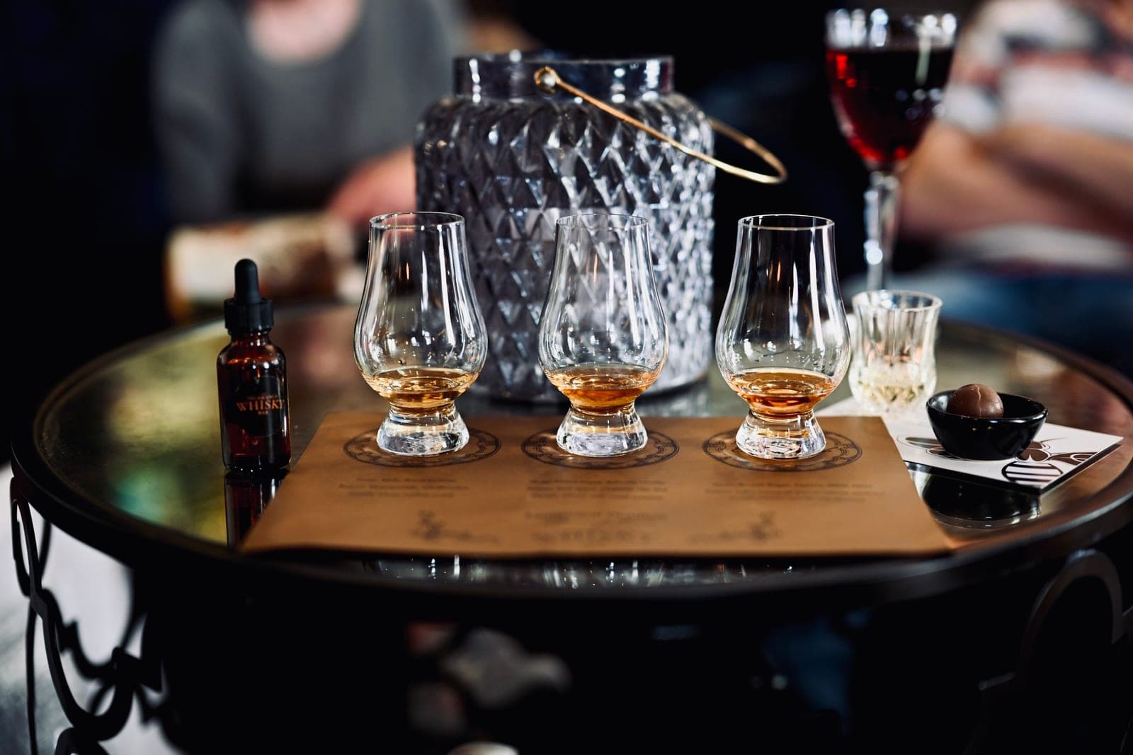 A tapered nosing glass holding whiskey at a tasting